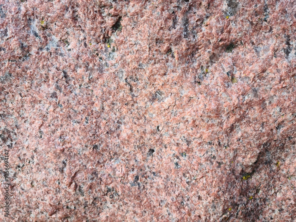 Textured surface of pink granite showing mineral details in natural light Textured surface of pink granite showing mineral details in natural light