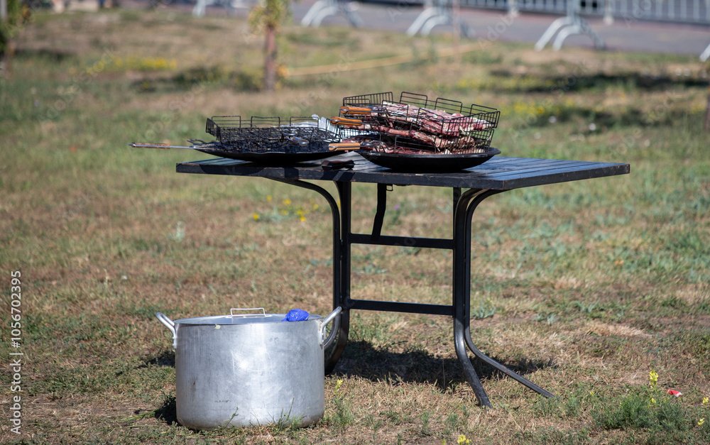 A table with a grill and a pot of food on it A table with a grill and a pot of food on it