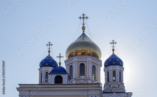 The blue and gold domes of a church tower are illuminated by the sun