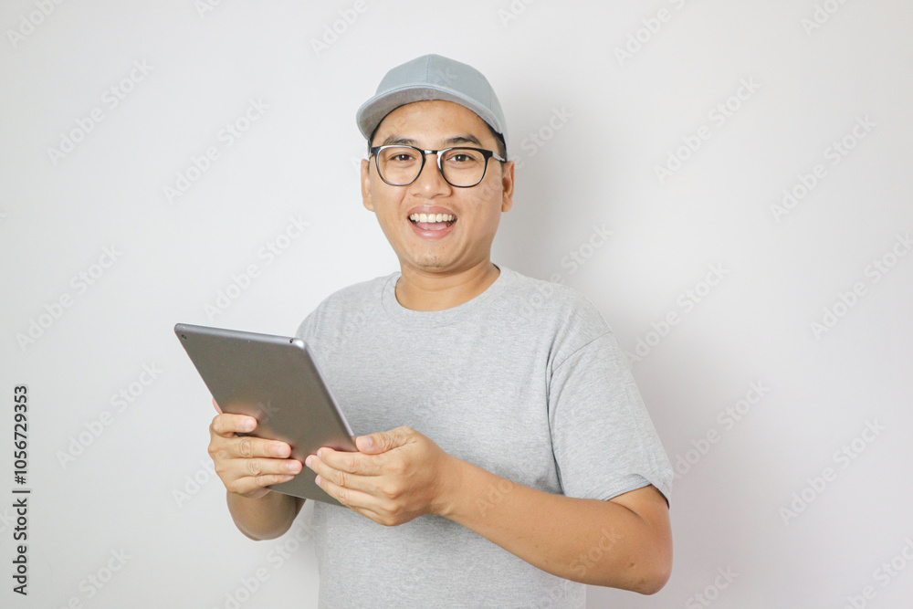 Asian Delivery man is pointing to a tablet in his hand, used for finding addresses, delivering packages, checking inventory, and shipment status, Isolated on a white background Asian Delivery man is pointing to a tablet in his hand, used for finding addresses, delivering packages, checking inventory, and shipment status, Isolated on a white background