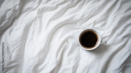 Top view of a coffee cup placed on a white bed