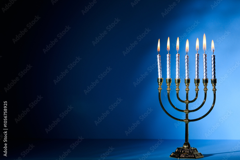 Hanukkah menorah with glowing candles on blue backdrop, symbolizing Jewish festival of lights Hanukkah menorah with glowing candles on blue backdrop, symbolizing Jewish festival of lights
