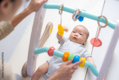 Mom play baby gym with her newborn baby