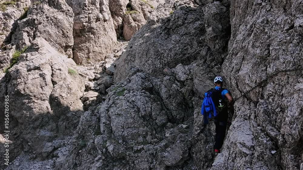 Man climbs rocky mountain walls, dangerous passages with chains, summer, Grignetta, and Italian Alps. Aerial lateral drone Man climbs rocky mountain walls, dangerous passages with chains, summer, Grignetta, and Italian Alps. Aerial lateral drone