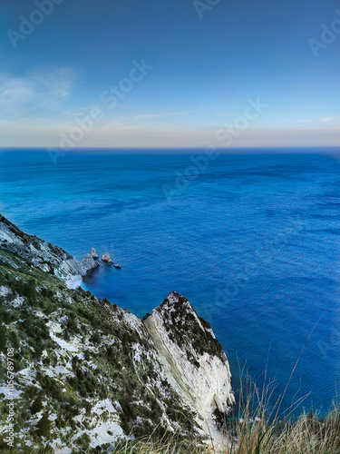 "Rocks and azure sea under a clear sky"

