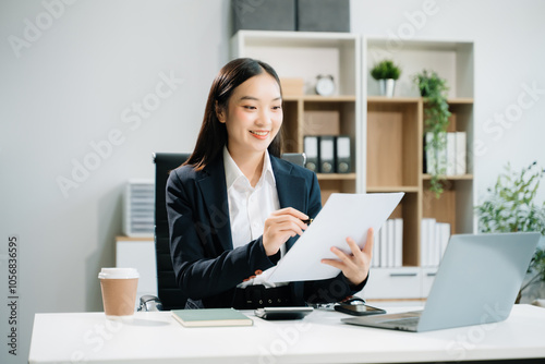 Business woman using tablet and laptop for doing math finance on an office desk,