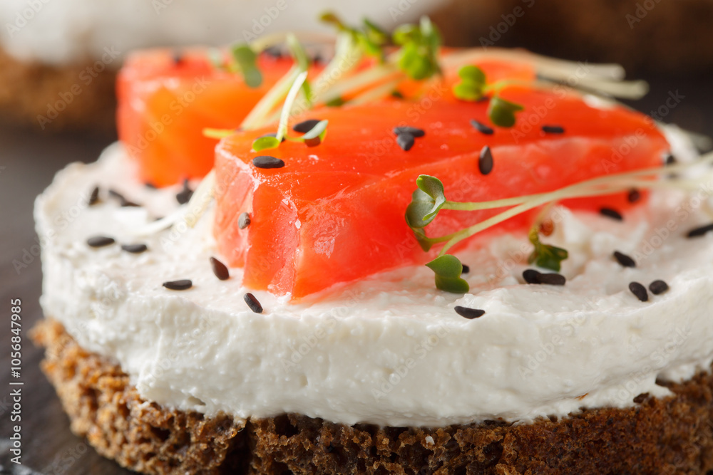 Spicy savory cheesecake with red fish, cream cheese, sesame and microgreens close-up on slate plate on table. Horizontal Spicy savory cheesecake with red fish, cream cheese, sesame and microgreens close-up on slate plate on table. Horizontal