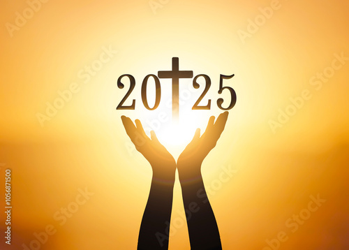 Silhouette of hands holding the new year 2025 and cross over sunset background