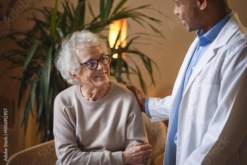 Compassionate Doctor Listening to Senior Patient. In this heartwarming scene, a young male doctor attentively listens to his elderly female patient during a house call. photo