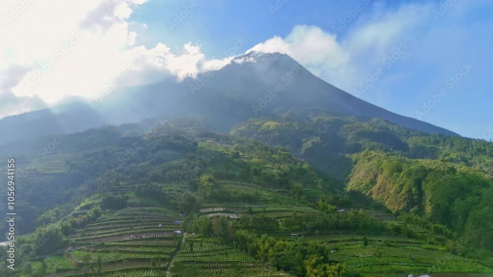 Aerial view of greenery tropical rural landscape on the slope of Merapi Volcano in sunny morning. Green plantation on the slope of Merapi Volcano. Indonesia. Aerial view of greenery tropical rural landscape on the slope of Merapi Volcano in sunny morning. Green plantation on the slope of Merapi Volcano. Indonesia.