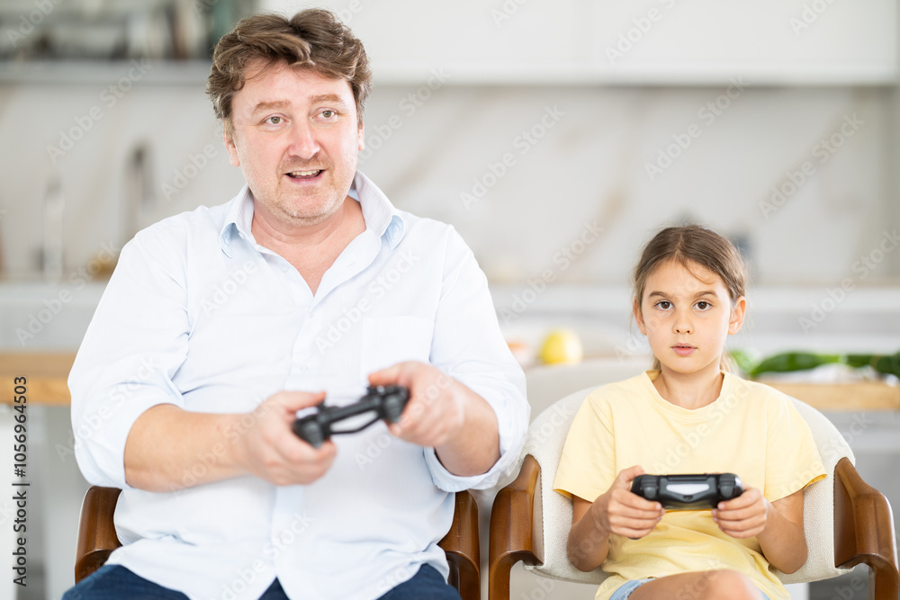 Father and daughter playing video game console Father and daughter playing video game console