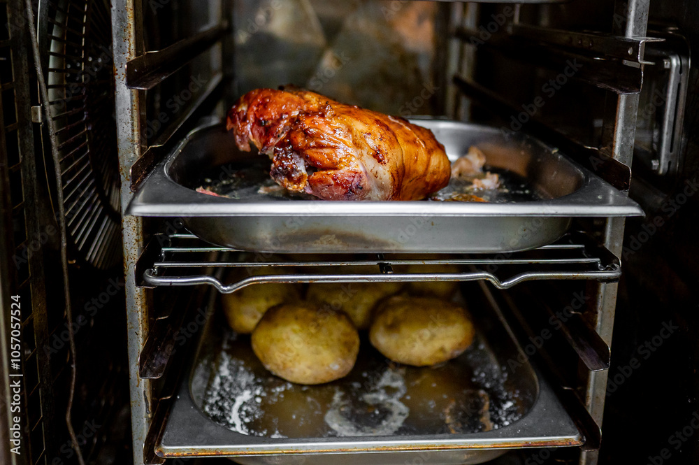 Close-up of succulent roasted meat wrapped in crispy bacon, sizzling in an oven tray with golden potatoes below. Perfect for a home-cooked meal or culinary content Close-up of succulent roasted meat wrapped in crispy bacon, sizzling in an oven tray with golden potatoes below. Perfect for a home-cooked meal or culinary content