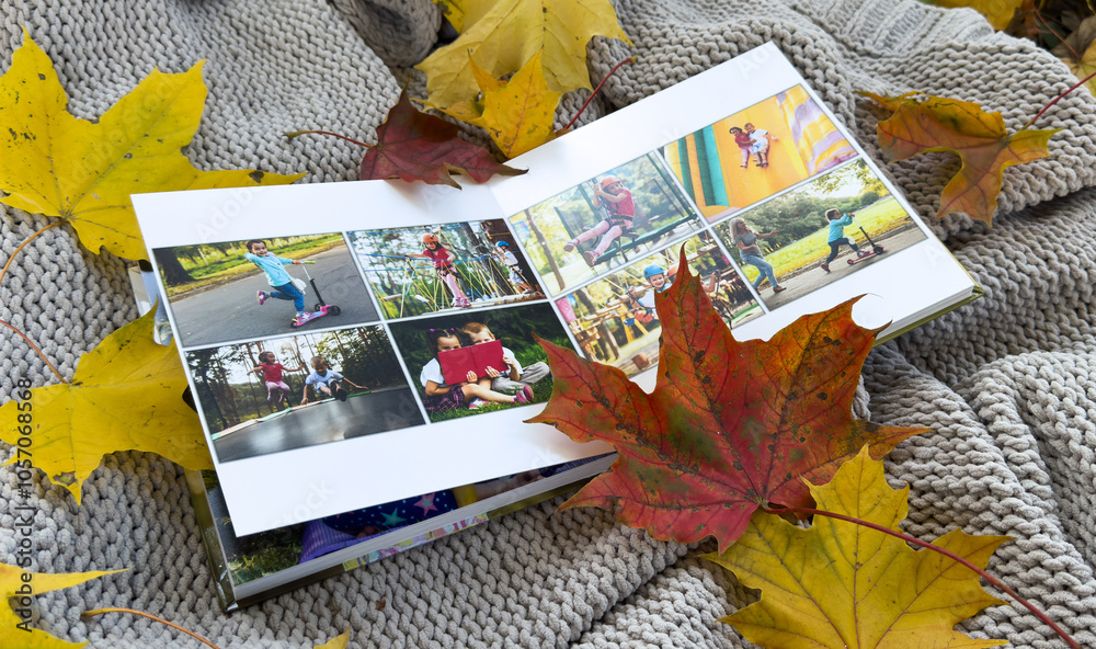 Naklejka premium Photobook on the leaves background, closeup of photobook, family photo album