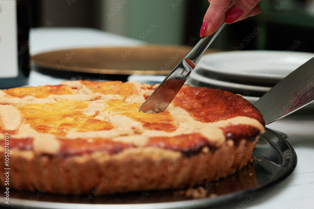 vista macro di una pastiera napoletana fatta in casa mentre viene tagliata a fette