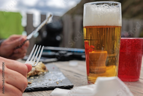 mani di persona adulta caucasica seduta ad un tavolo di legno, durante il pranzo photo