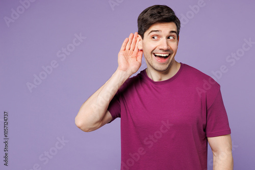 Young curious nosy Caucasian man he wear violet t-shirt casual clothes try to hear you overhear listening intently isolated on plain pastel light purple background studio portrait. Lifestyle concept. photo