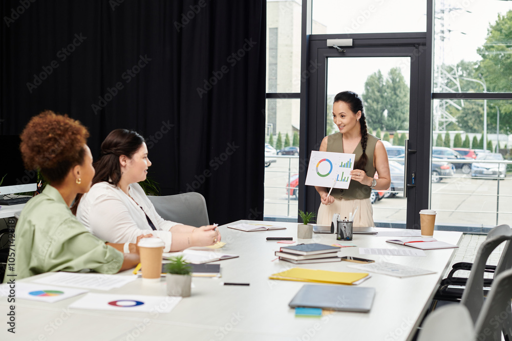 A confident woman presents ideas to her colleagues in a stylish office setting.