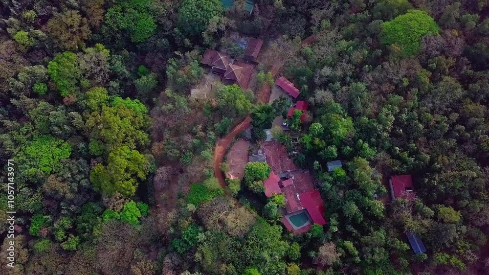 A lush resort hidden in the dense greenery of chikmagalur's tropical forest landscape, aerial view A lush resort hidden in the dense greenery of chikmagalur's tropical forest landscape, aerial view