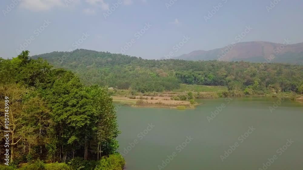 Hirekolale Lake in Chikmagalur with lush green trees, calm water, and distant mountain views Hirekolale Lake in Chikmagalur with lush green trees, calm water, and distant mountain views