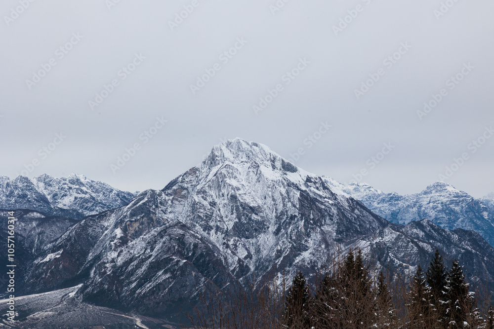 Fototapeta premium vista panoramica, in alta quota, sul territorio montano, freddo ed innevato, in inverno, nel Friuli Venezia Giulia settentrionale, di giorno, con cielo nuvoloso