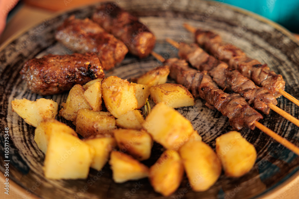 piatto italiano del Friuli Venezia Giulia a base di patate al forno, spiedini di carne e cevapcici
