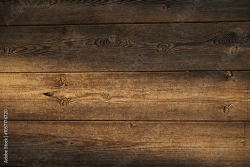 vista dettagliata frontale di varie tavole di legno marrone, nella penombra, illuminate parzialmente dal sole
