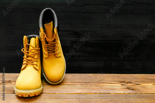 Tableau sur toile Brown warm mountain winter Timberland tracking shoes, boots, sneakers, trainers on wooden background