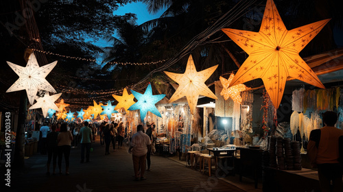 Fototapeta Naklejka Na Ścianę i Meble -  Vibrant night market street decorated with illuminated star-shaped lanterns, featuring people walking and shopping among various small stalls and outdoor displays under a canopy of trees.