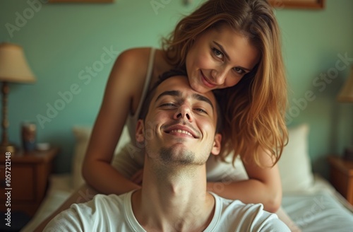 Couple enjoying a playful moment together in a cozy bedroom during a sunny afternoon