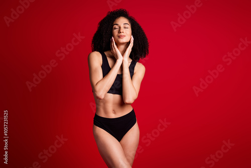 Photo portrait of lovely young lady touch soft face skin dressed black lingerie no filter isolated on red color background