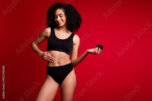 Photo portrait of lovely young lady hold apply body cream jar dressed black lingerie no filter isolated on red color background