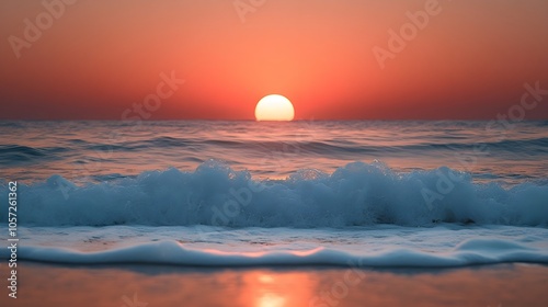 Picturesque sunset over the sea A dramatic view of a sunset with the sun setting over the ocean in warm orange tones as the waves gently crash onto the shore. photo