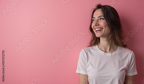 Cheerful woman laughing joyfully against pink background with copy space