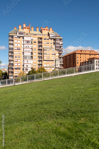 A city scene featuring a multi-story apartment complex with a vibrant green lawn in the foreground, under a clear blue sky, depicting modern urban living in Logrono Spain photo