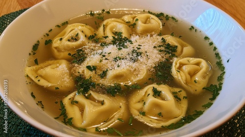 Delicate tortellini in brodo broth, served in a bowl with a sprinkle of parmesan and fresh herbs