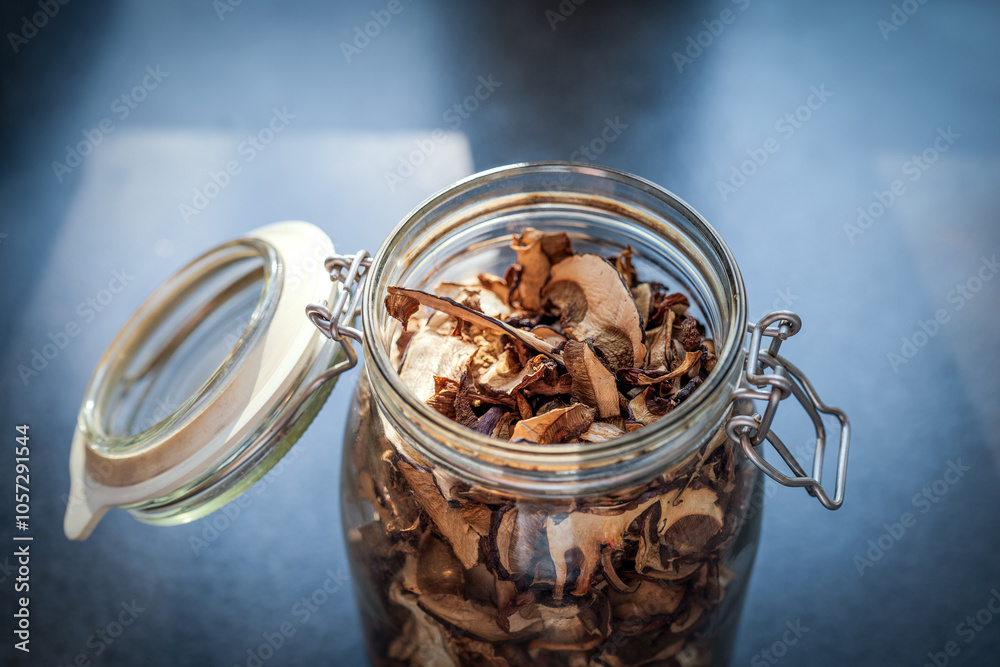 Open glass jar with dried mushrooms. Top view
