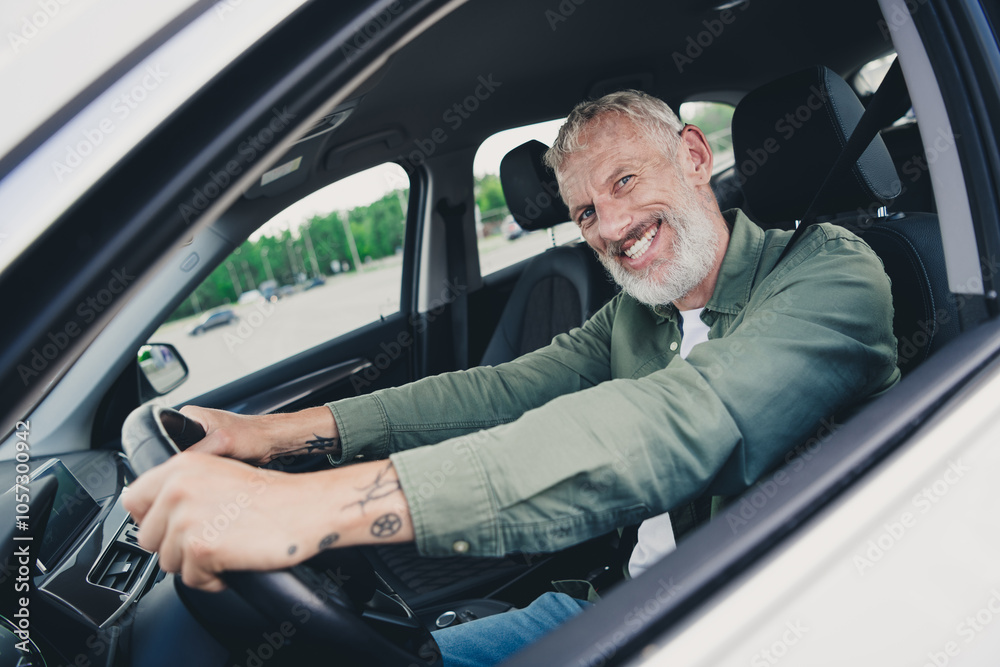 Photo of attractive funny retired guy wear khaki shirt riding automobile outdoors urban city street