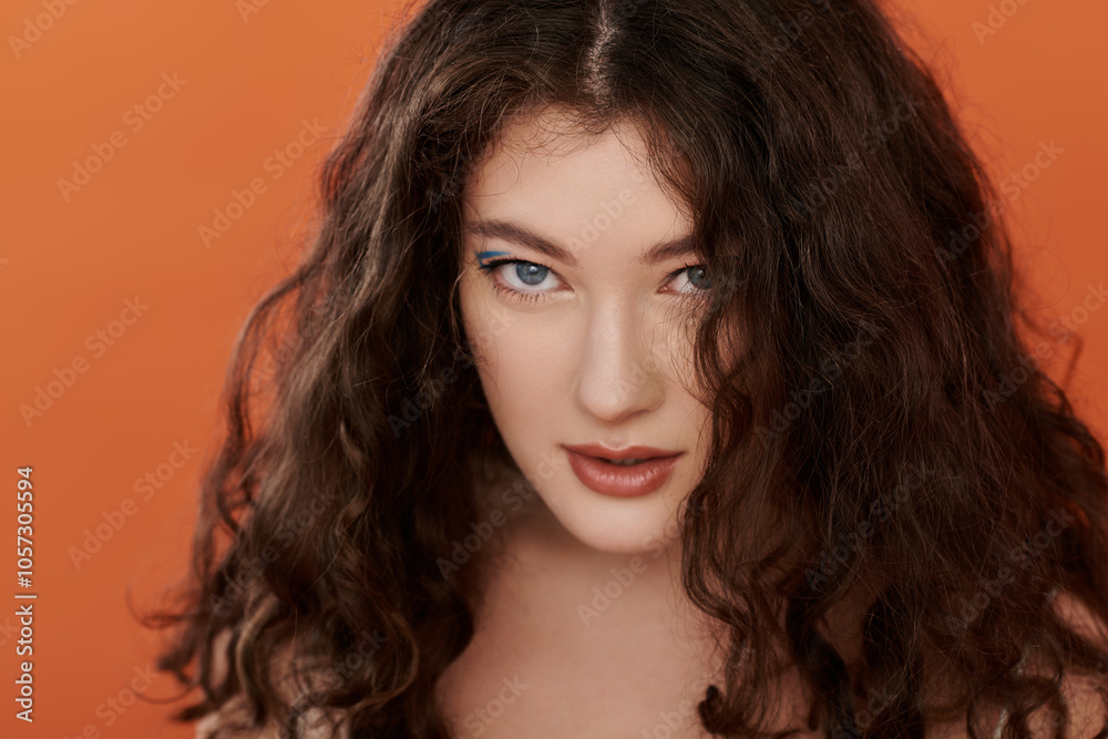 A beautiful plus size woman showcases her style, accentuated by vibrant orange surroundings. A beautiful plus size woman showcases her style, accentuated by vibrant orange surroundings.