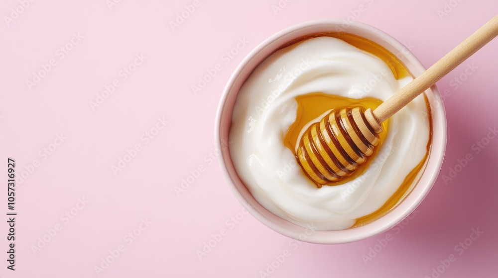 A bowl of Greek yogurt drizzled with honey on a soft pink background showcasing its probiotic and calcium benefits