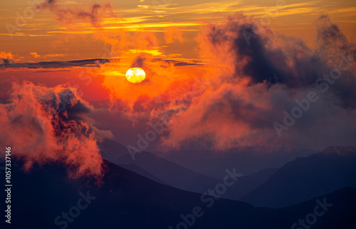 Clouded, colorful sunset over mountains
