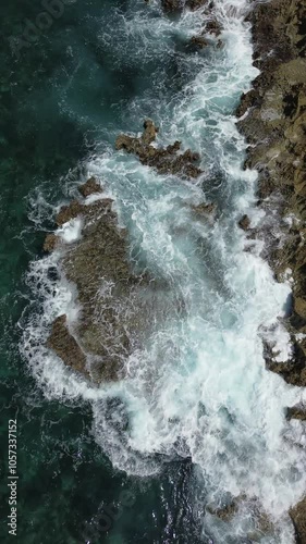 Beautiful Caribbean sea coast with deep blue ocean water crashing on the rocks and cliffs and making waves on the sunny tropical island of Curacao - aerial drone flight shot 