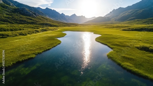 A sunlit valley opens up to a peaceful lake surrounded by rolling hills and distant mountains, with sunlight sparkling on the water, embodying calm and beauty. photo