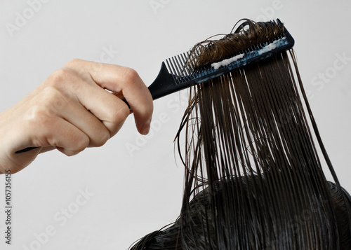 Combing wet hair with a nourishing mask. photo