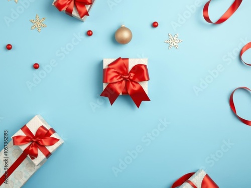 Red gift box with shiny satin bow on a festive blue background with space for text, celebration, top view
