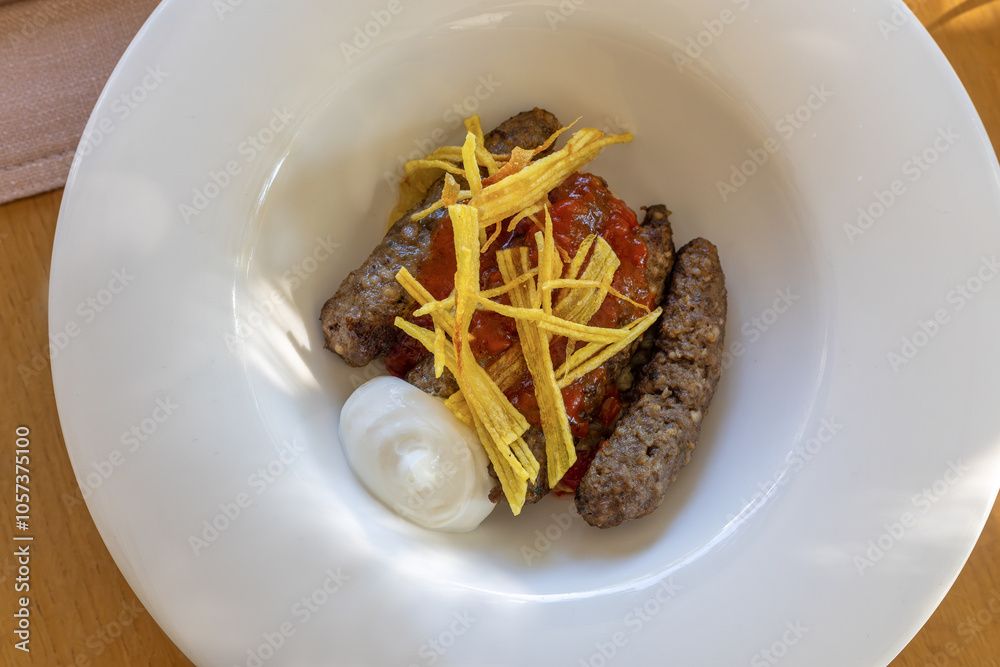 Mirada meatballs, grated and cooked potatoes, served with tomato sauce.