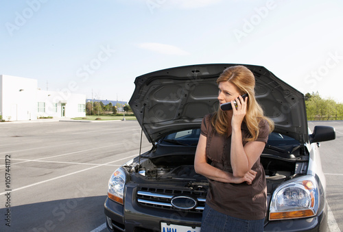 Woman Having Car Trouble and Using Cell Phone to Call for Help photo