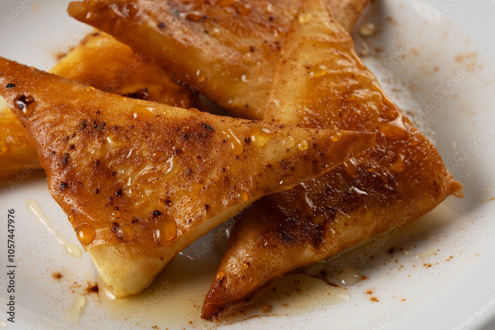 Mini cheese pies with myzithra, cretan honey and cinnamon on white plate. Mini cheese pies with myzithra, cretan honey and cinnamon on white plate.