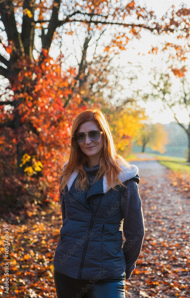 Young redhead beautiful woman in sunglasses pose in autumn foliage landscape. Lifestyle, leisure background Young redhead beautiful woman in sunglasses pose in autumn foliage landscape. Lifestyle, leisure background