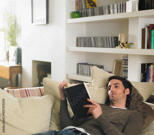 Man Lying Down on Sofa Reading Book photo