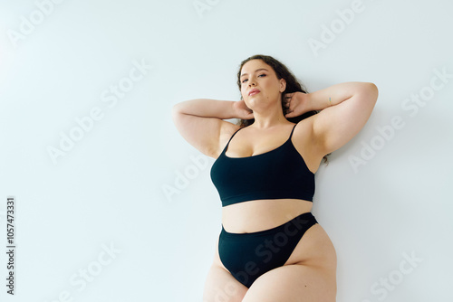 A stunning plus size woman exudes confidence while striking a pose, showcasing her beauty.